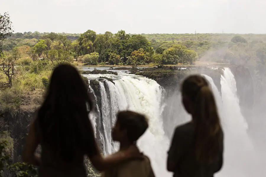 Children view the waterfall at Victoria Falls, Zambia.