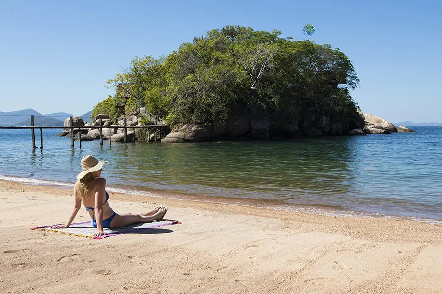 Woman sits on the banks of Lake Malawi on Mumbo Island, Malawi.